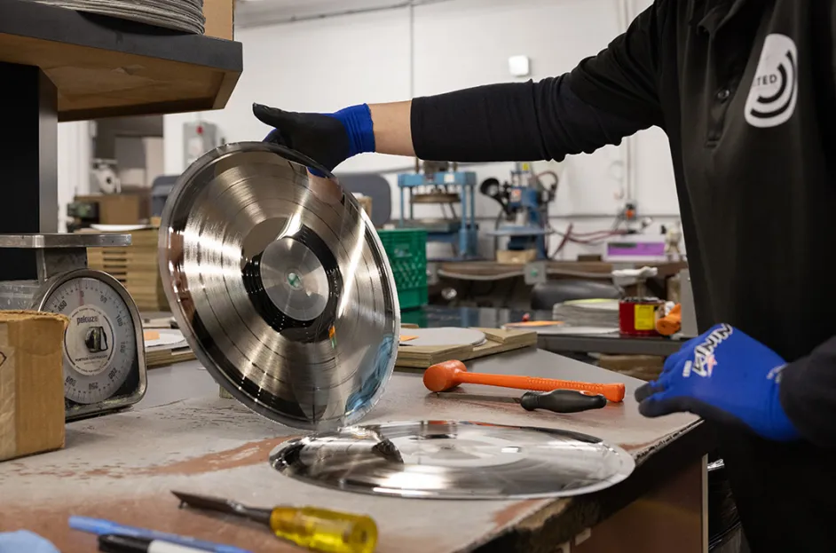 United Record Pressing employee separating a metal stamper from a metal mother in plating shop