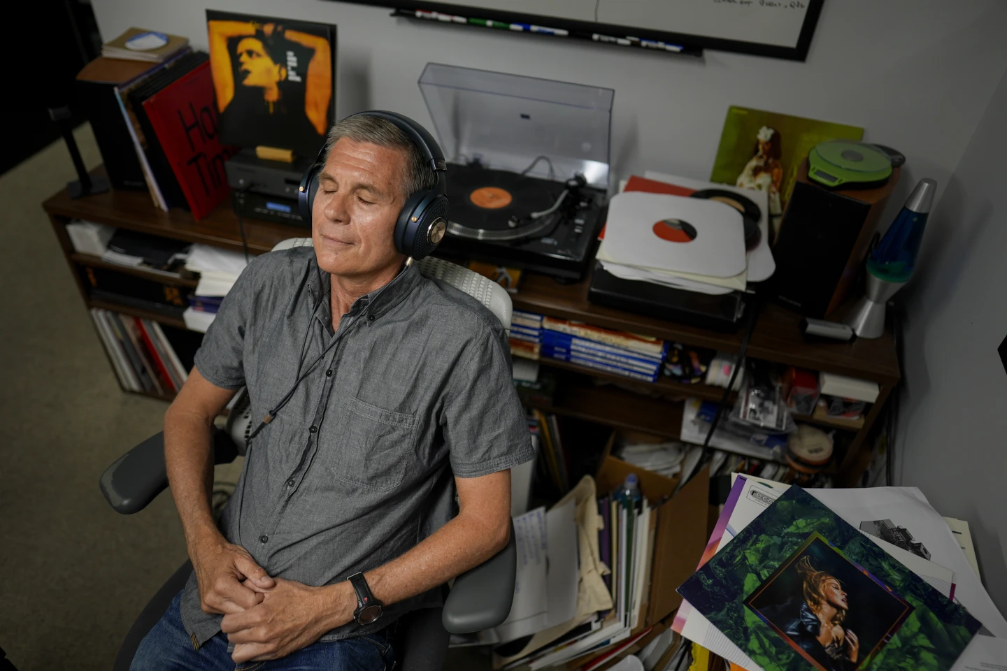 CEO Mark Michaels listening to a vinyl record with headphones on